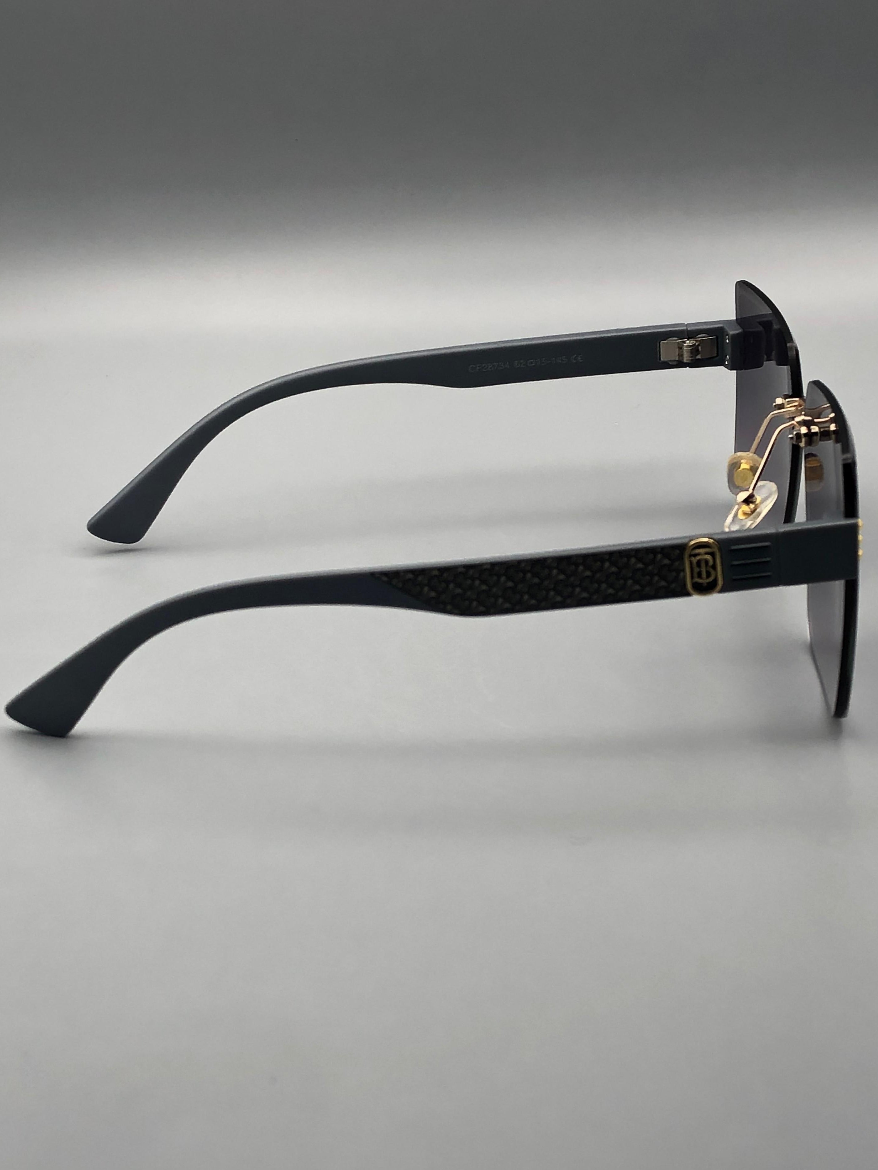 Black sunglasses with gold accents on a gray background