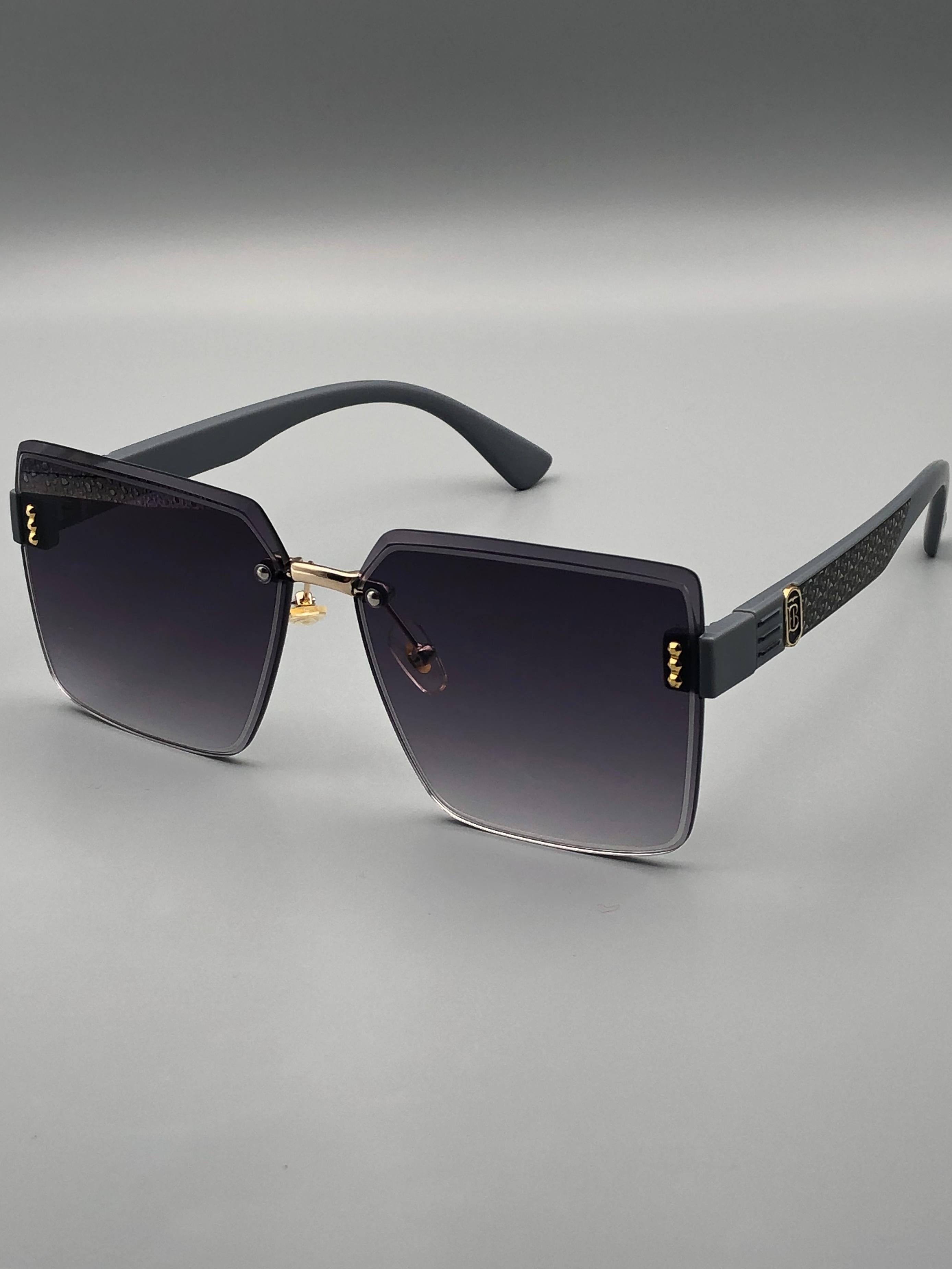 Billionaire Sunglasses with black gradient lenses and gold accents on a gray background