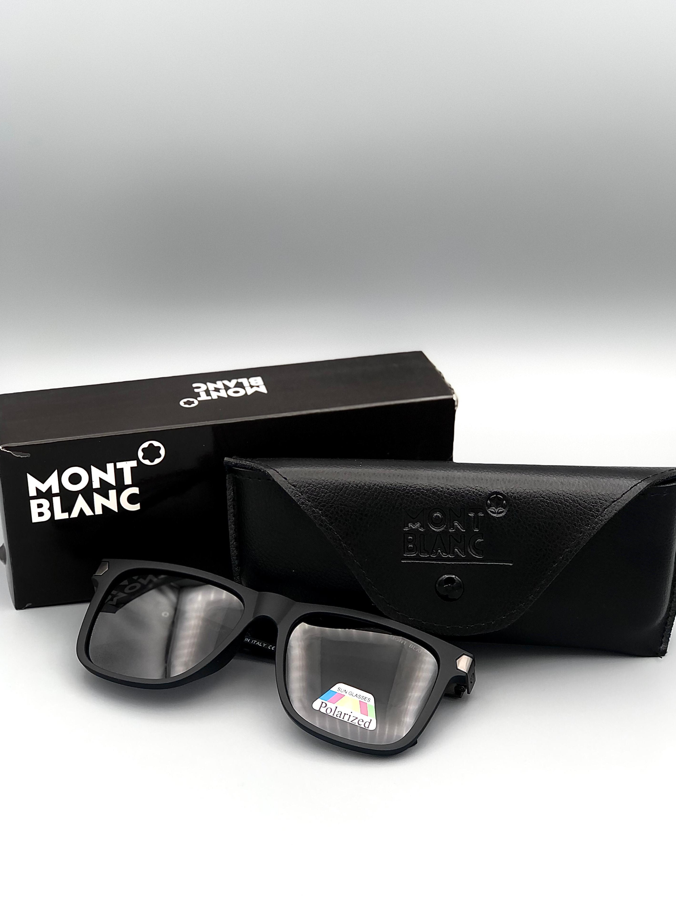 Black sunglasses with a Montblanc case on a gray background